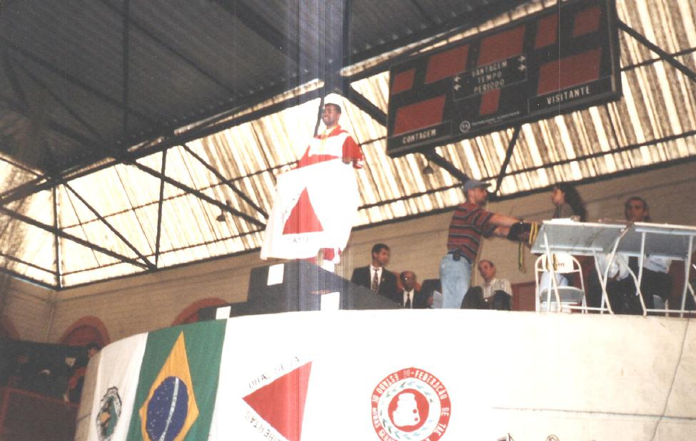 Atleta no pódio com bandeira de Minas Gerais